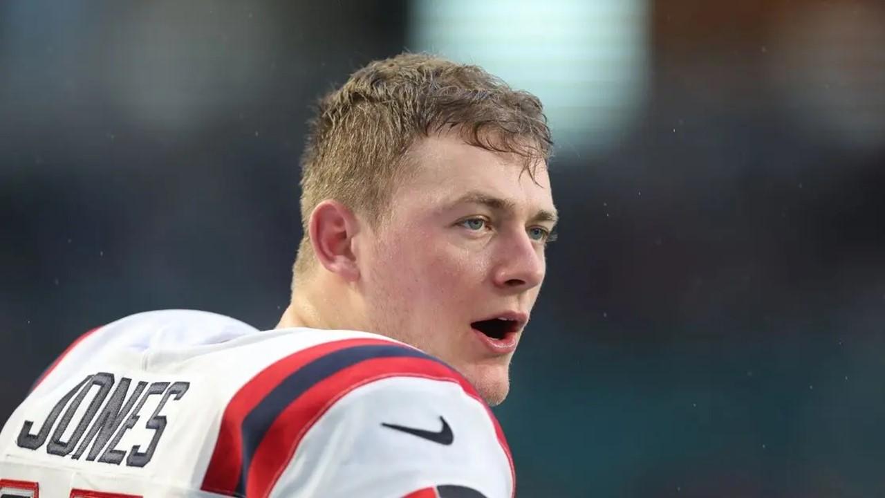 Mac Jones #10 of the New England Patriots stands on the sideline against the Miami Dolphins on Jan. 9, 2022