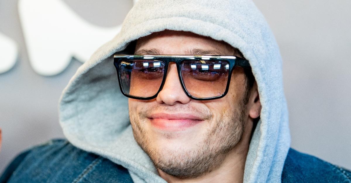 pete davidson in jean jacket with gray hoodie over his head and sunglasses while at bupkis premiere at apollo theater in nyc